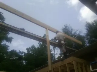 Carpenter setting a ridge beam over a new addition frame — Ice Dam Removal by Roofing Brothers in Swan Valley