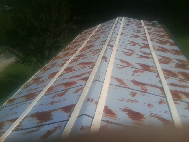 Rusted metal roof panels with new wood purlins before replacement — Storm Damage Roof Repair in Swan Valley by Roofing Brothers